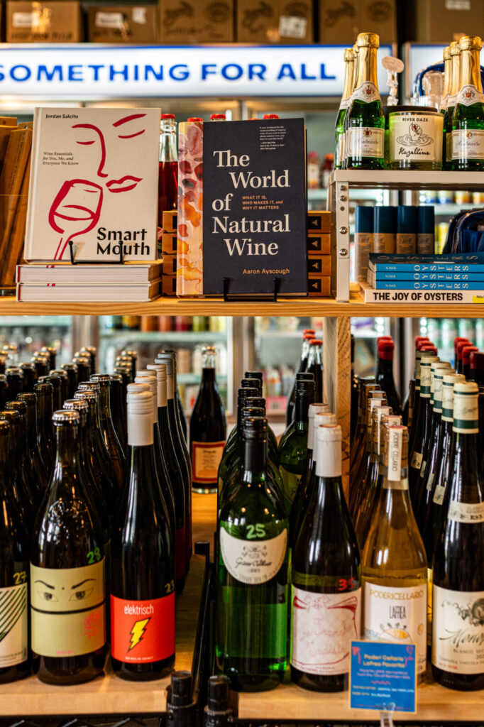 Natural wine bottles and wine books on shelves inside Miss Market
