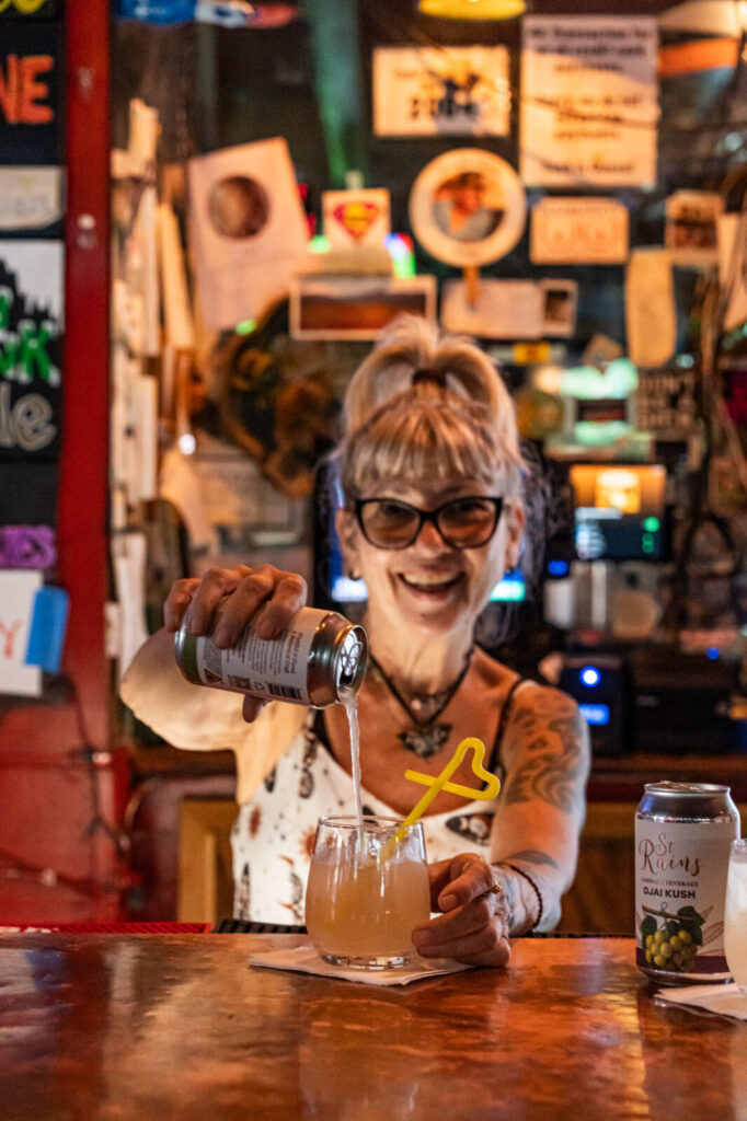 Bartender pouring a can of St. Rains Ojai Kush into a glass at the MRB bar